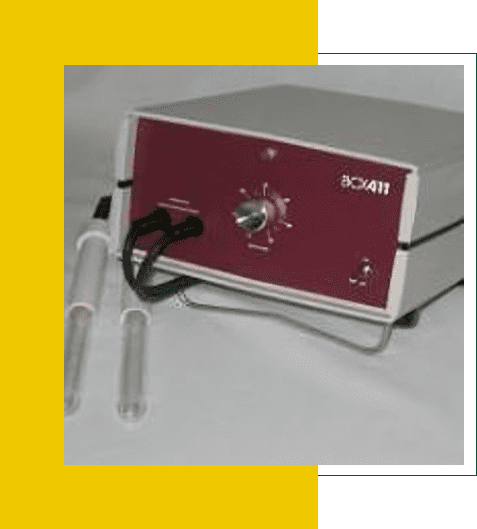 A laboratory device with tubes and controls on a yellow surface.