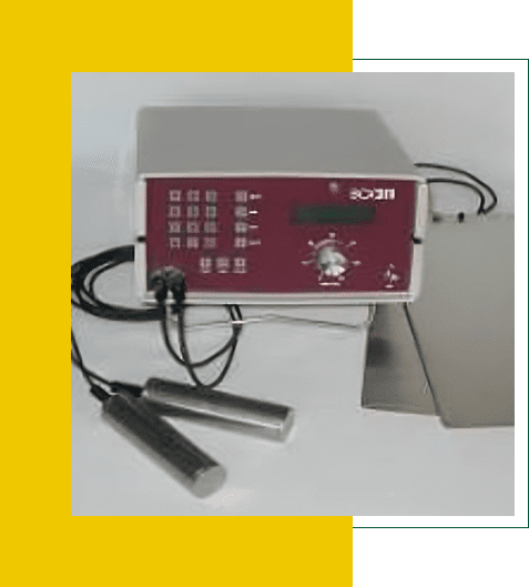 A digital device with cables and probes on a yellow background.