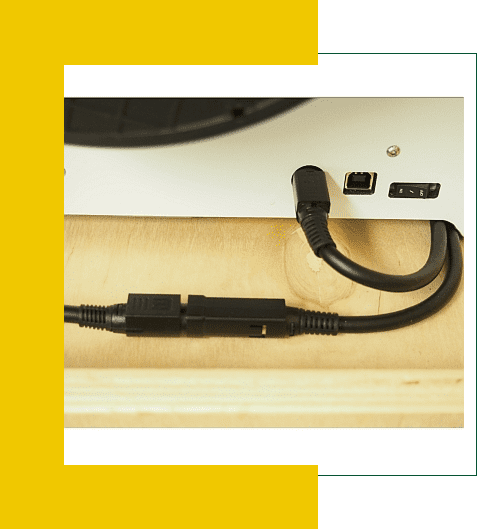 Close-up of connected black HDMI and USB cables on a wooden surface.