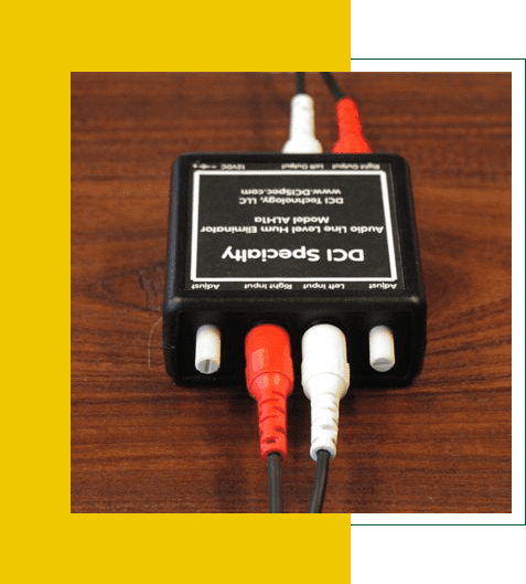 DC power supply with red and white cables connected on a wooden surface.
